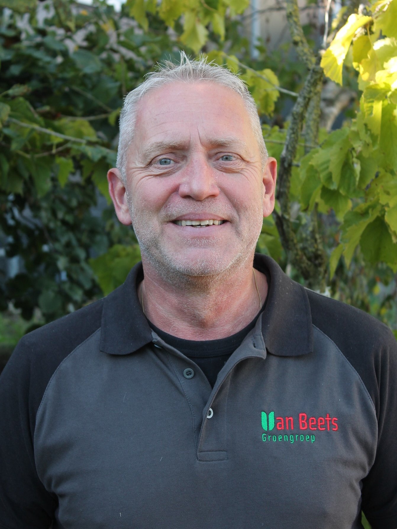 Meine van Beets, oprichter van Van Beets, buiten voor het groen in een Van Beets-polo